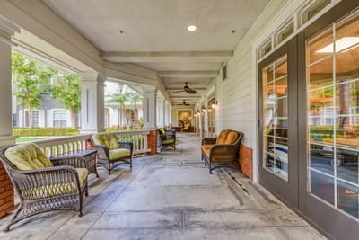Covered porch area with seating and greenery
