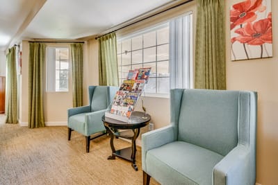 Cozy common area with blue chairs and magazines