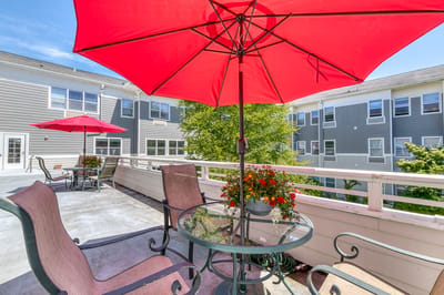 Outdoor seating area with red umbrellas and flowers