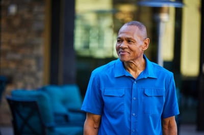 A resident smiling while walking outdoors in the community