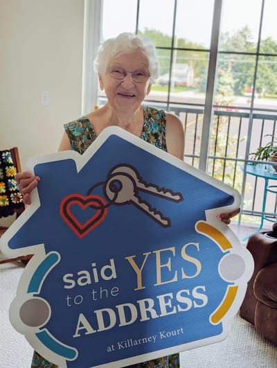 Resident holding a sign celebrating the facility