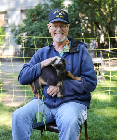 A resident outdoors with a puppy in a garden