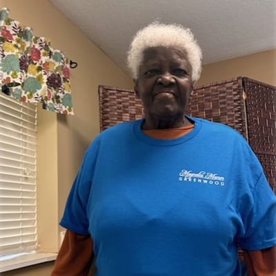 Resident in a blue shirt with facility name
