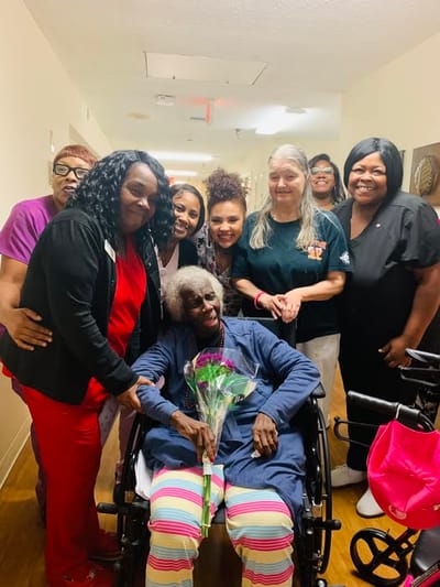 Residents and staff celebrating together in a hallway