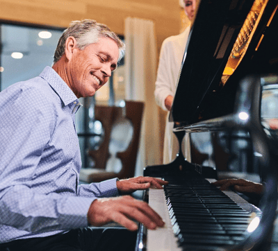 Resident enjoying music at the piano in a common area