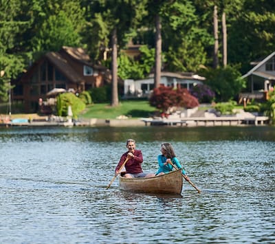 Two residents enjoying a canoe ride on a lake