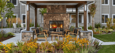 Outdoor seating area with flowers and a fireplace