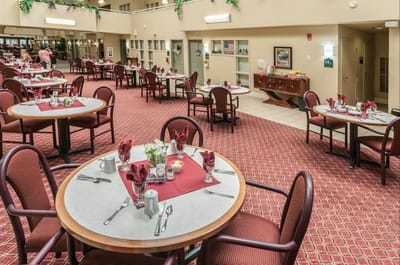 Dining room setup with tables and chairs for residents