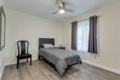 Simple bedroom setup with a bed and chair