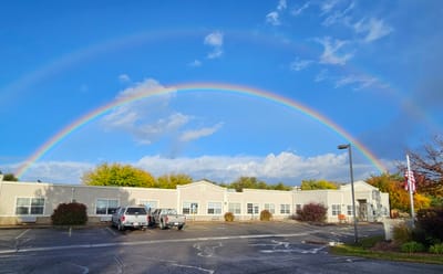 Building exterior under a rainbow in the sky