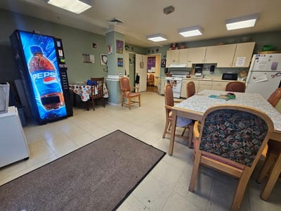 A dining area with tables and kitchen equipment