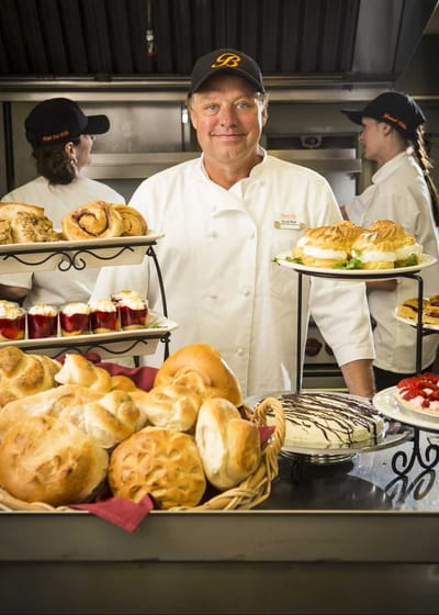 A chef presenting a variety of baked goods