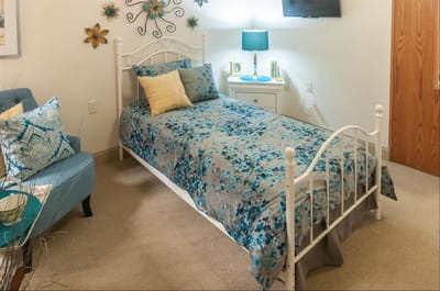 Brightly decorated resident room with a bed and seating