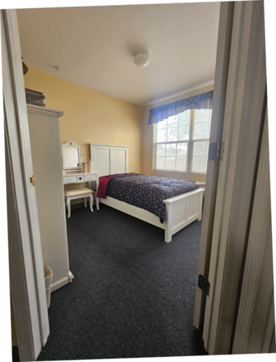 A cozy private resident room with a bed and desk