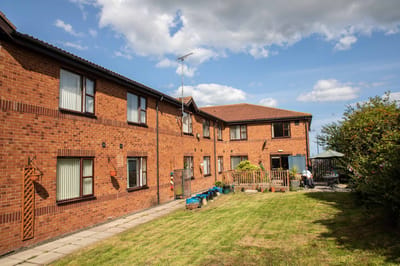 Exterior view of the Marigold Nursing Home building with residents