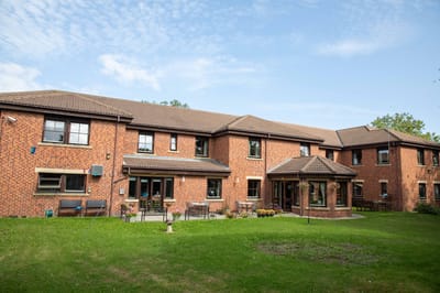 Exterior view of Marigold Nursing Home with gardens
