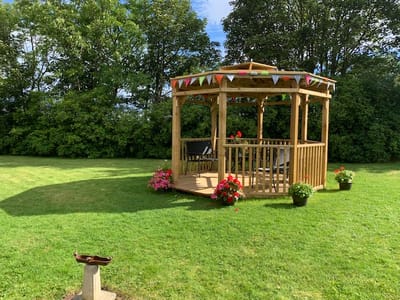 Outdoor gazebo surrounded by greenery and flowers