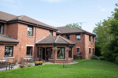 Exterior view of a nursing home building with garden