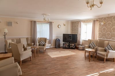 Bright common area with sitting chairs and television