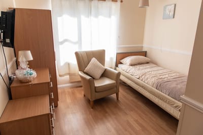 Cozy private room with a bed and armchair