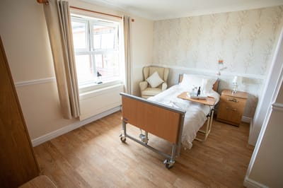 Brightly decorated resident room with a bed and chair