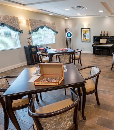 Bright common area with tables and a piano
