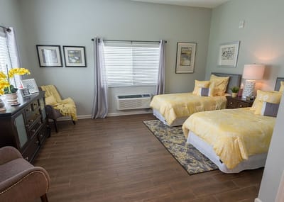 Cozy double room with yellow bedding and artwork