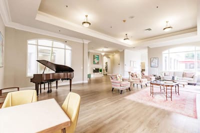 Bright common area with a grand piano and seating