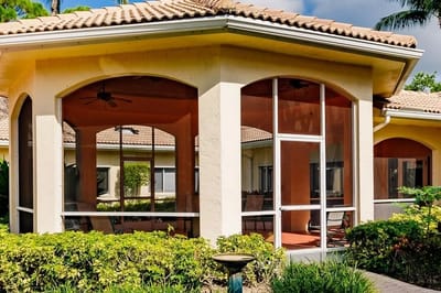 Exterior view of a screened patio area with landscaping