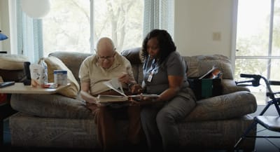 Staff member and resident looking at an album together