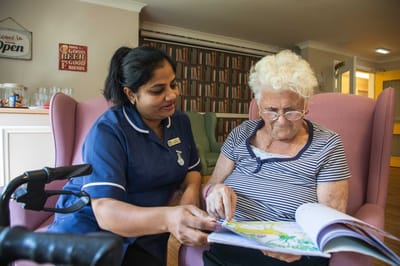 Staff member assisting a resident with coloring