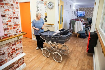 Staff member pushing a stroller in a hallway