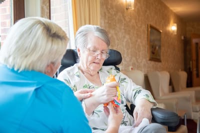Staff assisting a resident in a common area