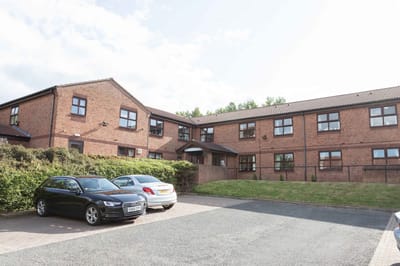 Exterior view of Marigold Nursing Home with parking spaces