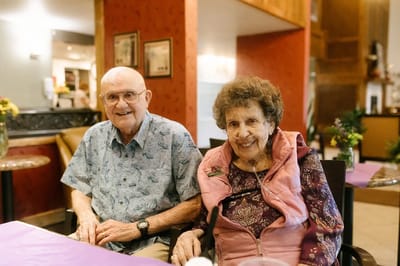 Elderly couple smiling together in a common area