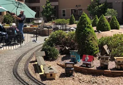 Residents enjoying an outdoor garden with train display