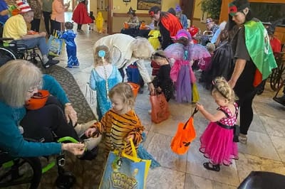 Residents and children celebrating Halloween in a common area