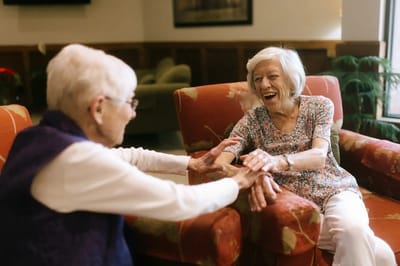 Two elderly women enjoying a moment in a cozy lounge