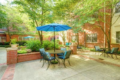 Outdoor seating area with a blue umbrella and plants