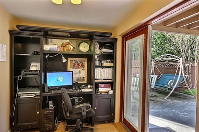 An interior office space with a view of a patio swing