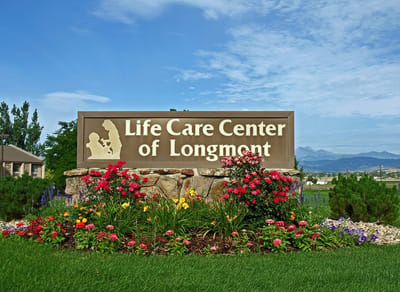 Facility logo with flowers and mountains in the background