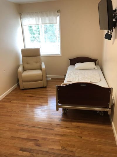 A quiet private resident room with a bed and chair