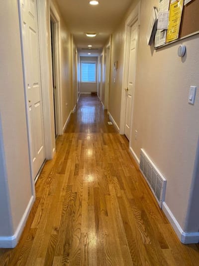 Long hallway with wooden flooring and doors