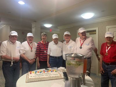 Residents celebrating with medals and a cake