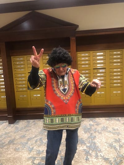 Resident dressed in vibrant attire celebrating an event indoors