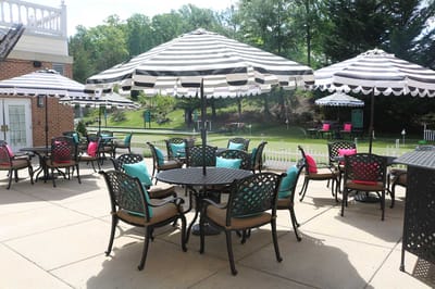 Outdoor seating area with striped umbrellas and colorful chairs