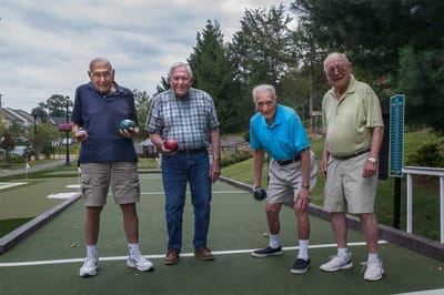 Four residents bowling on an outdoor court