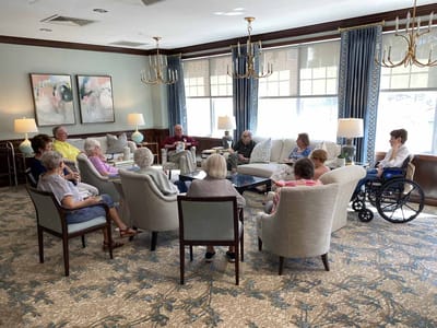 Residents engaged in conversation in a comfortable lounge area