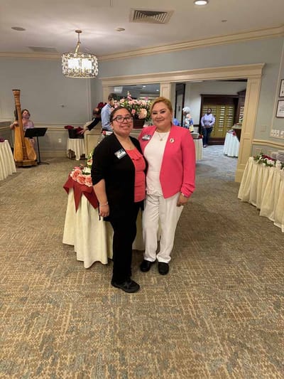 Two staff members in a decorated common area