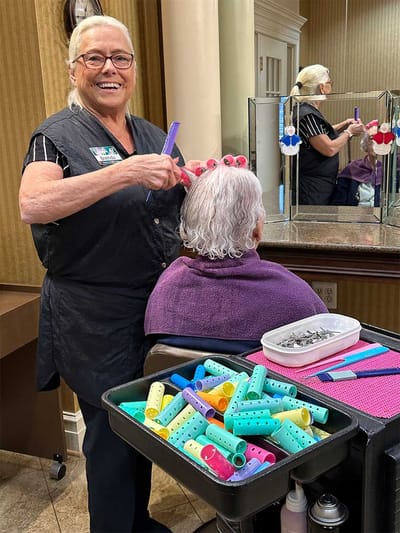 Stylist giving a hair treatment to a resident